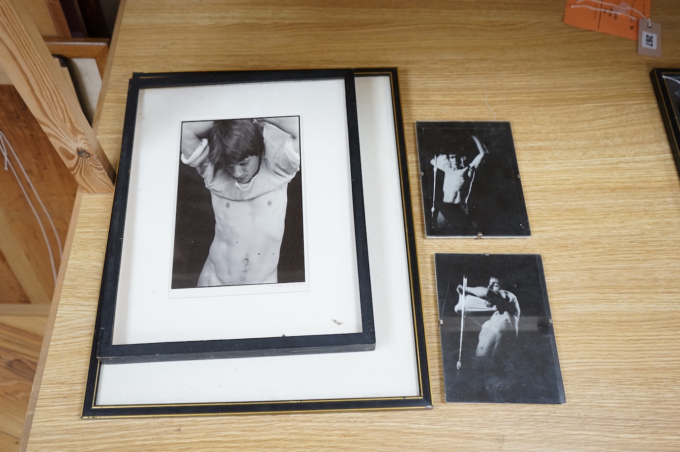 Paula Court - photographic silverprint, man taking T-shirt off, dated 1982, and three other photographs relating to the 1980’s downtown New York artscene, the first 23x15cm. Condition - fair.